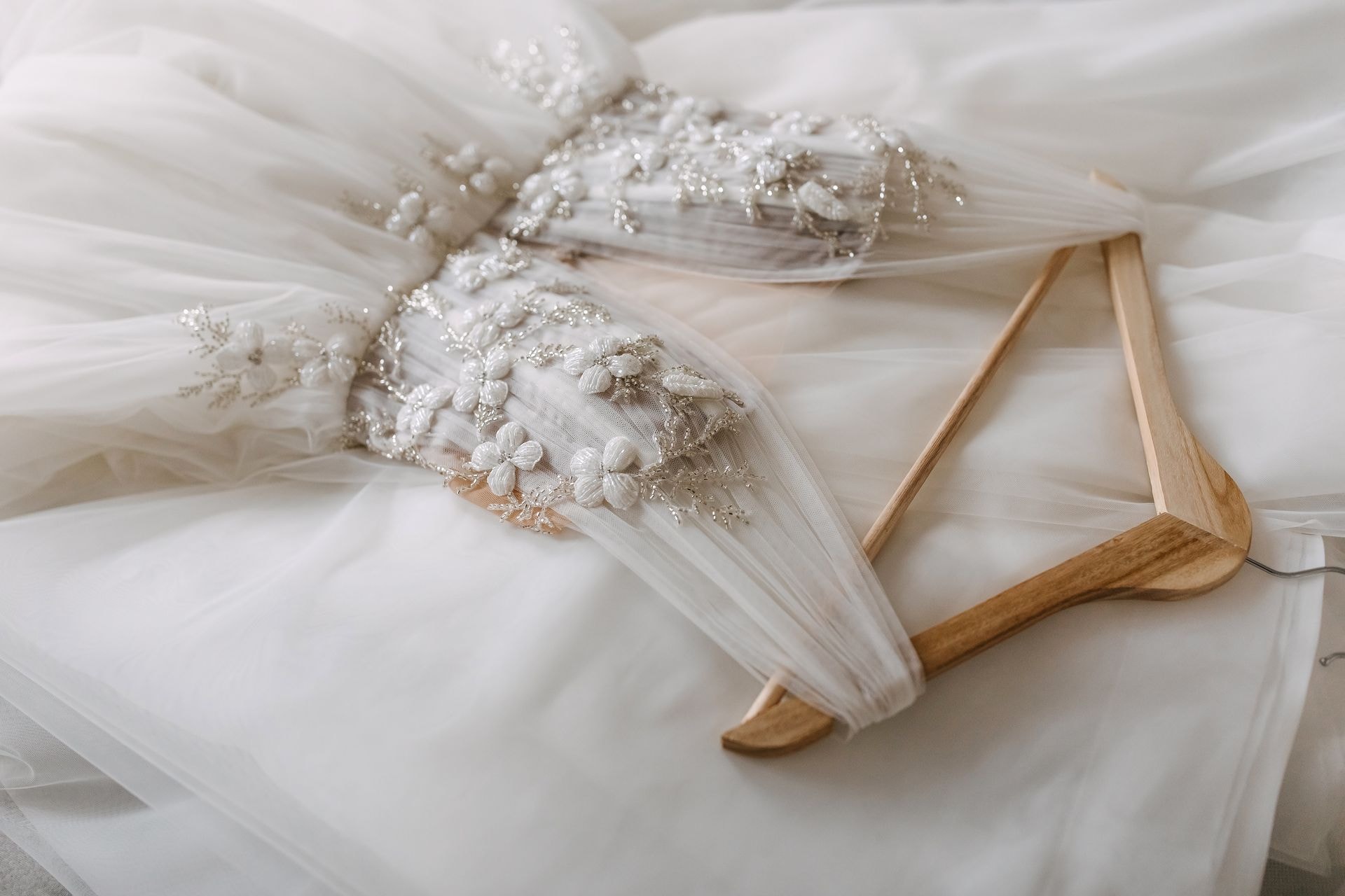 Seamstress carefully adjusting delicate lace on a bridal gown